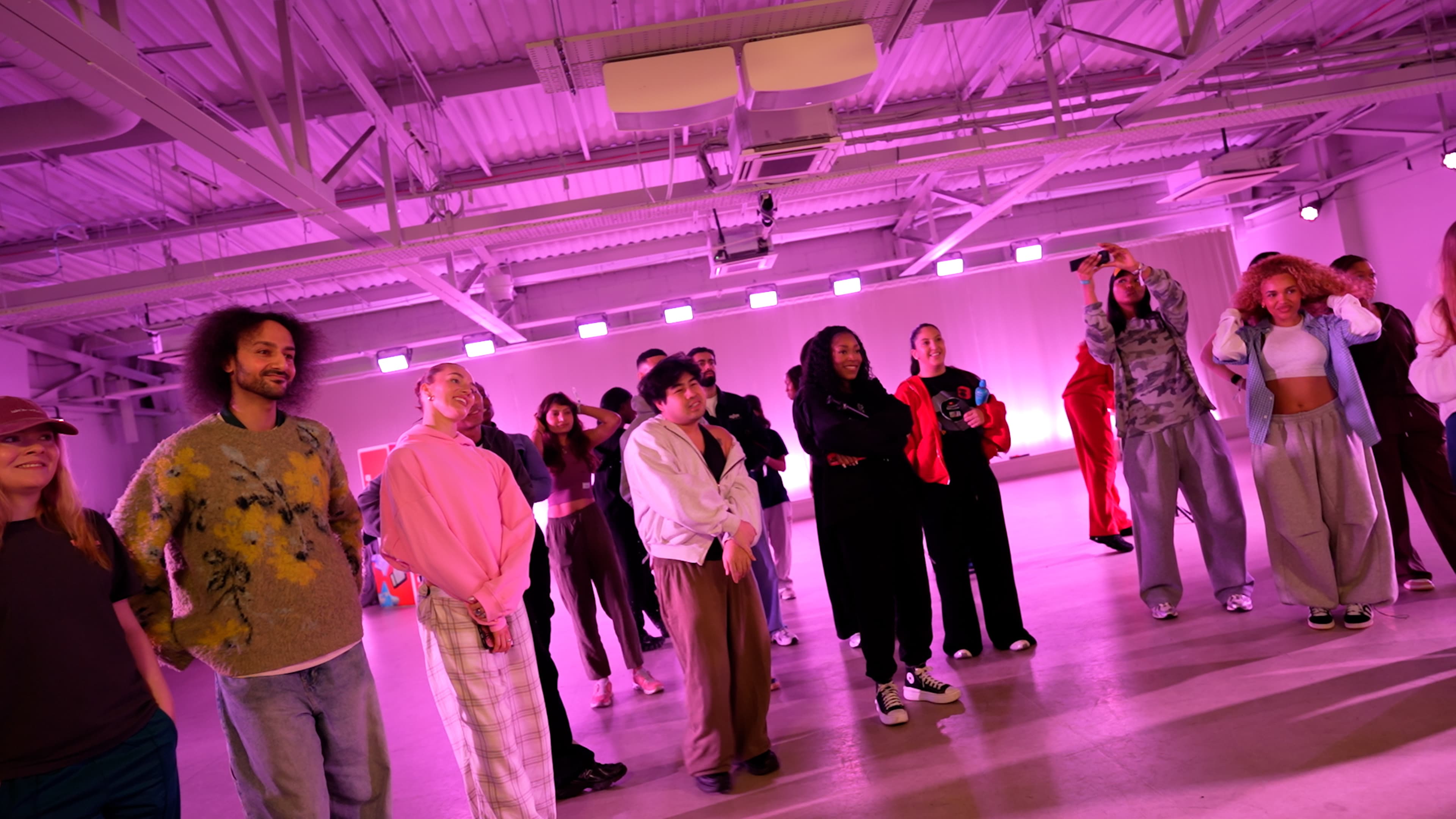 YouTube Creator Collective event at The Manor LDN, with creators taking part in a branded dance workshop and social experience under vibrant pink and purple lighting, alongside group moments and YouTube-branded event details.